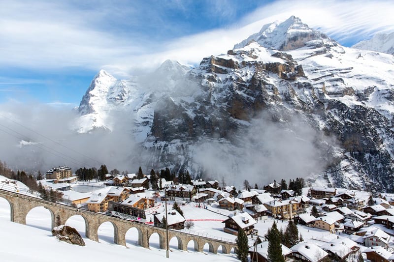 Mürren na neve, com o funicular do Allmendhubel e as nuvens subindo pelas montanhas.
