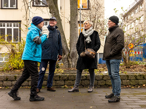 A group of guests actively listening to the guide telling a story