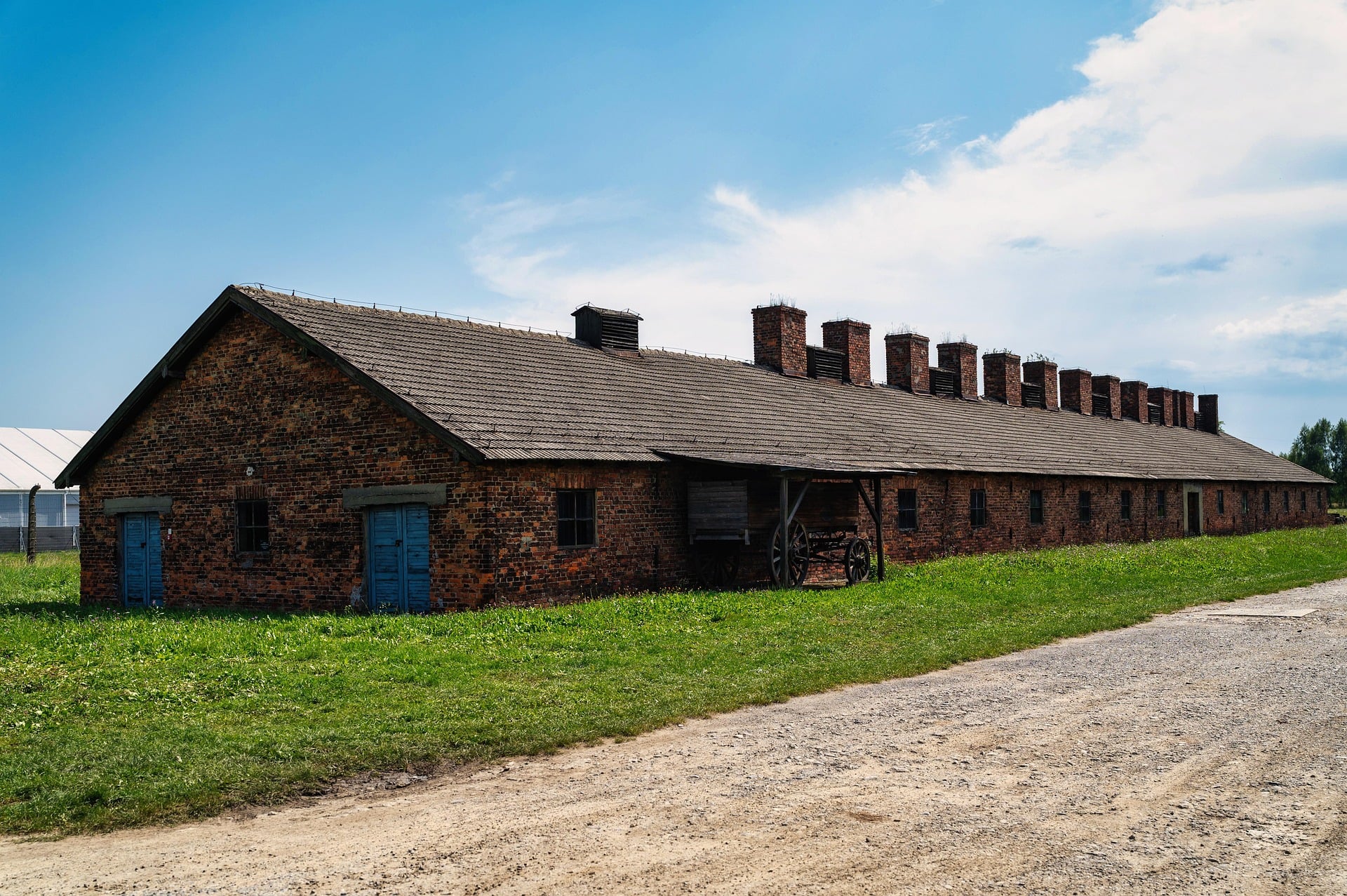 Another of Auschwitz I's brick blocks, with the original heating chimneys still visible along the roofline.