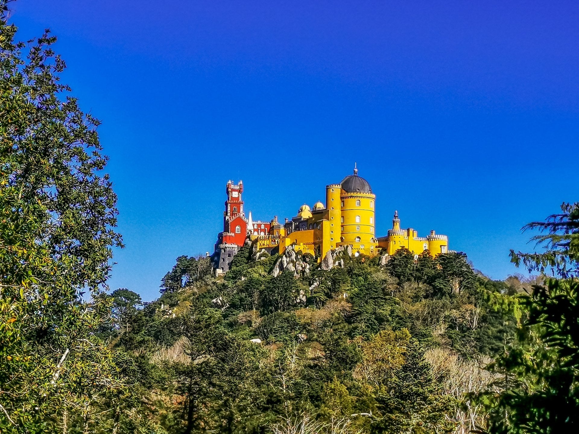Pena Palace and its yellow towers on the hilltop in Sintra