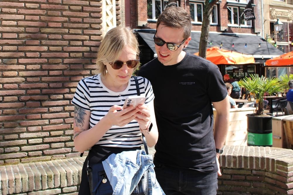 Players solving puzzles during the City Detective game in Leeuwarden at Waagplein.