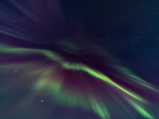 The Northern Lights dance across the night sky.