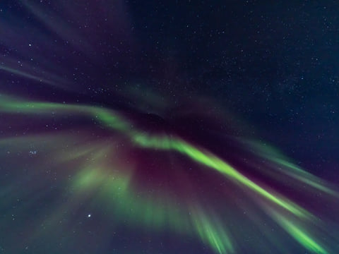 The Northern Lights dance across the night sky.