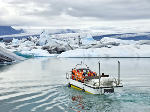 A tour group on board of a amphibious vehicle travelling across the glacier lagoon at Jokulsarlon