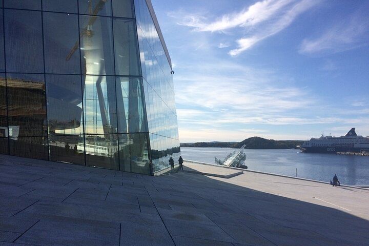 Looking at the Oslo Opera large windows, and fjord behind, while standing on the roof