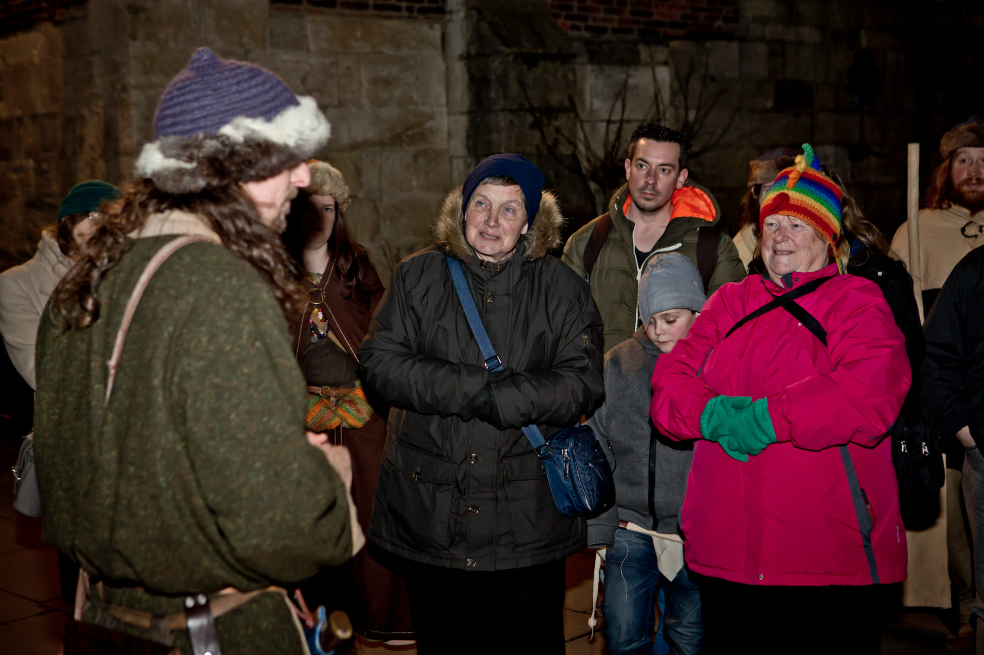 A viking guide with his guests at St. Mary's Church, Coppergate, York, at night.