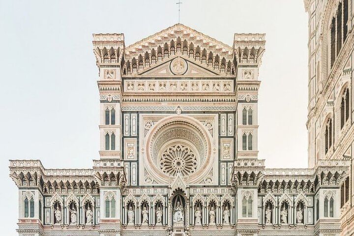 Frontal view of the highest part of Santa Maria del Fiore's façade with its rose window and withe and green marble