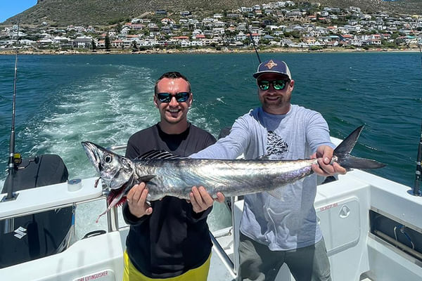 Proudly displaying the catch amidst Simon's Town's scenic shoreline.