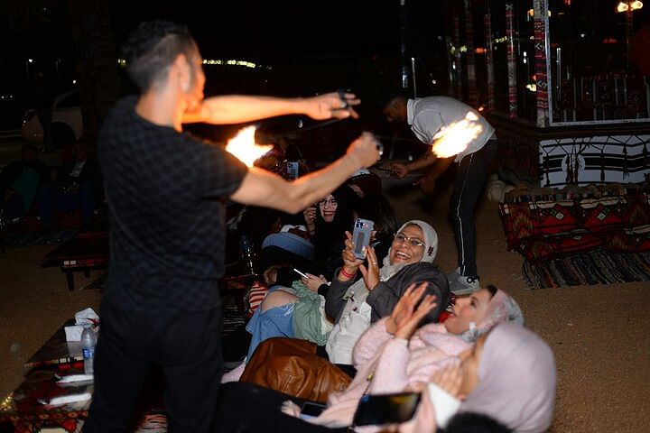 Tourists relaxing in a Bedouin tent while enjoying traditional tea in the Sharm El Sheikh desert.