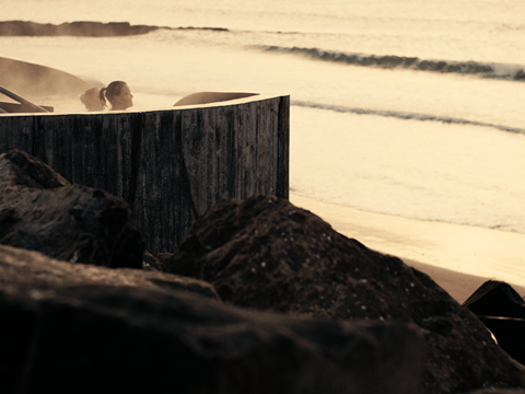 Guests enjoying a bath in the Guðlaug Geothermal Bath