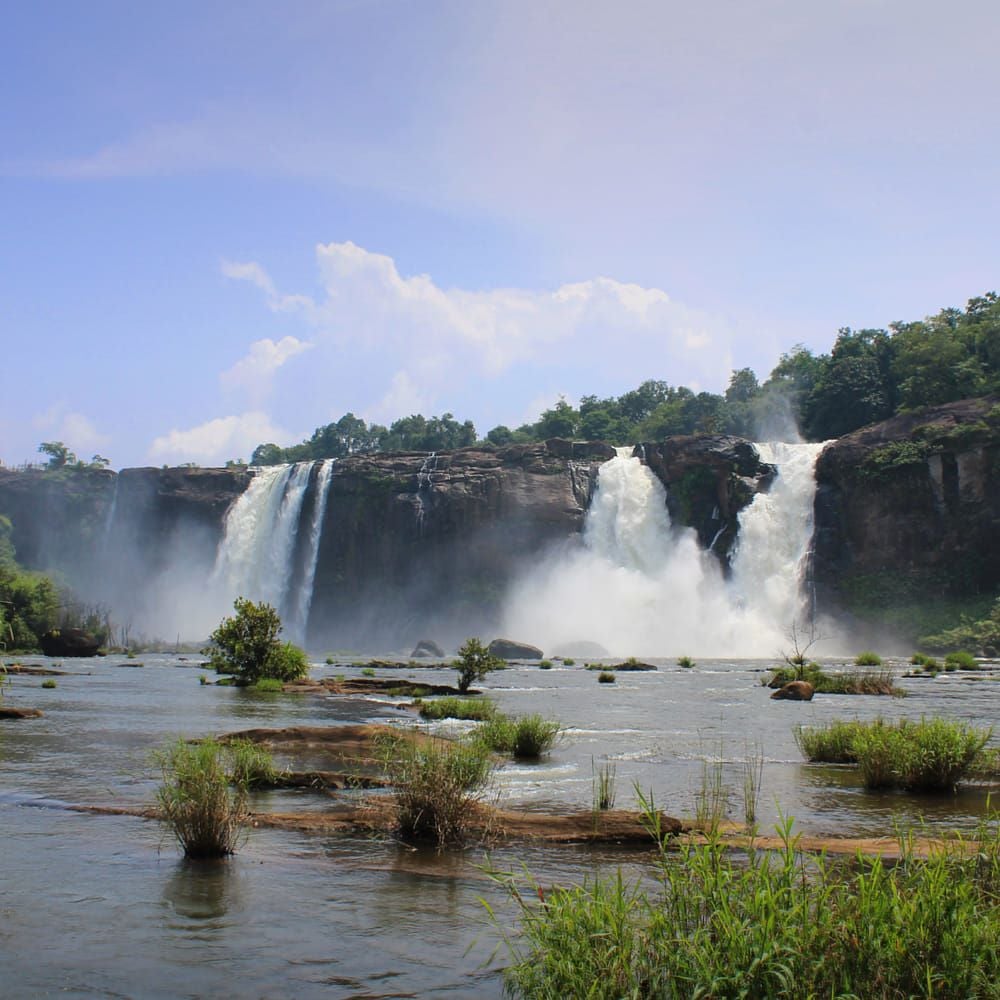 Wide view of Athirappilly waterfalls cascading over rock ledges