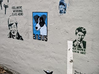 Small graffiti art pieces on a house wall in downtown Reykjavik