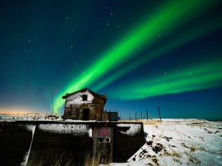 Abandoned house with northern lights over
