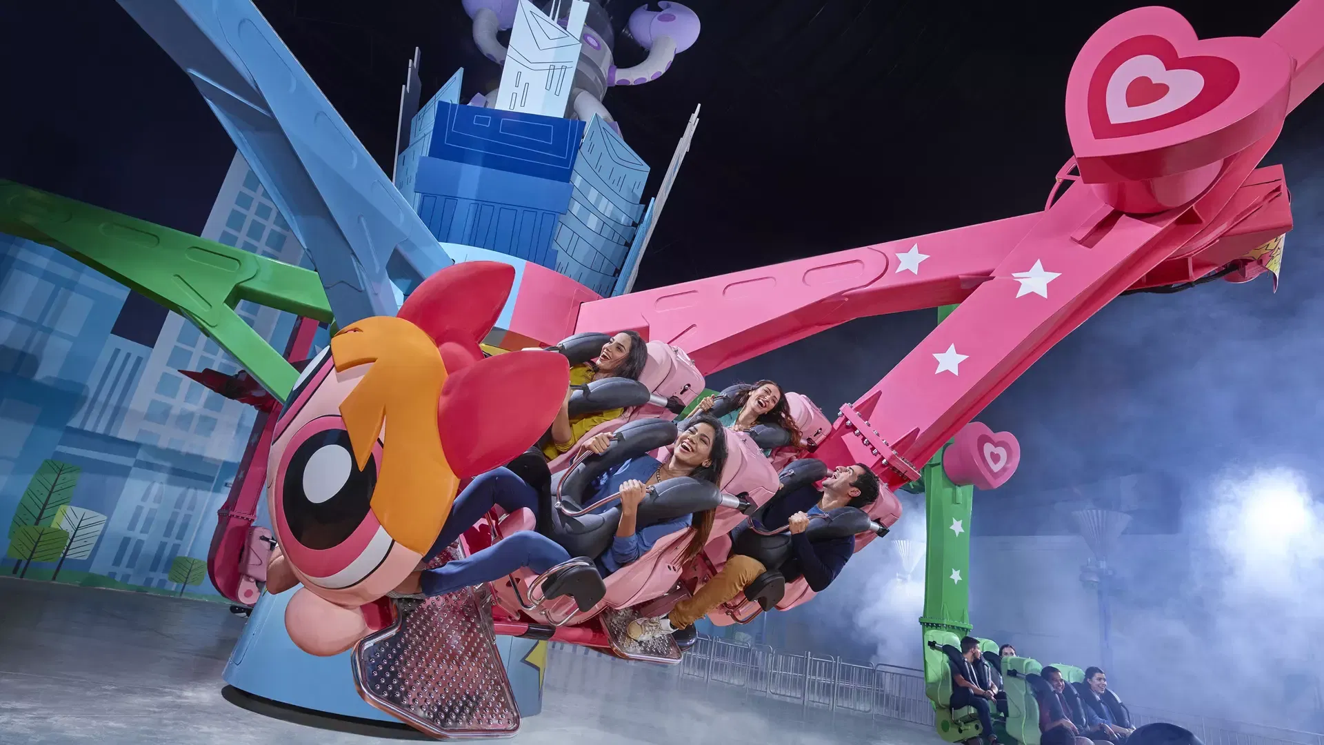 Excited riders swing through the air on an amusement ride featuring cartoon characters at IMG Worlds of Adventure Theme Park.