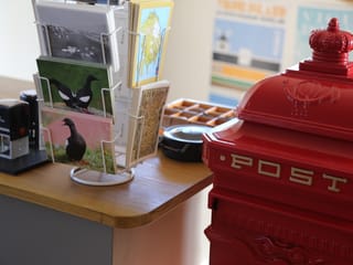 Postcards displayed next to a red post box