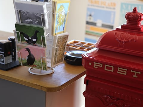 Postcards displayed next to a red post box