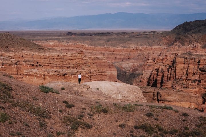 Wide desert canyon with layered cliffs and rugged terrain in Central Asia