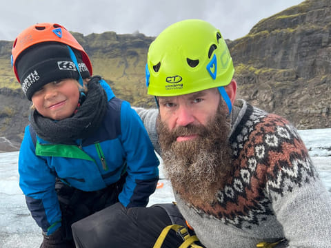 The glacier guide and a boy are making a "Viking face" on the glacier.