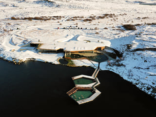 A picture showing Vök baths geothermal pools in their winter clothing covered in snow.