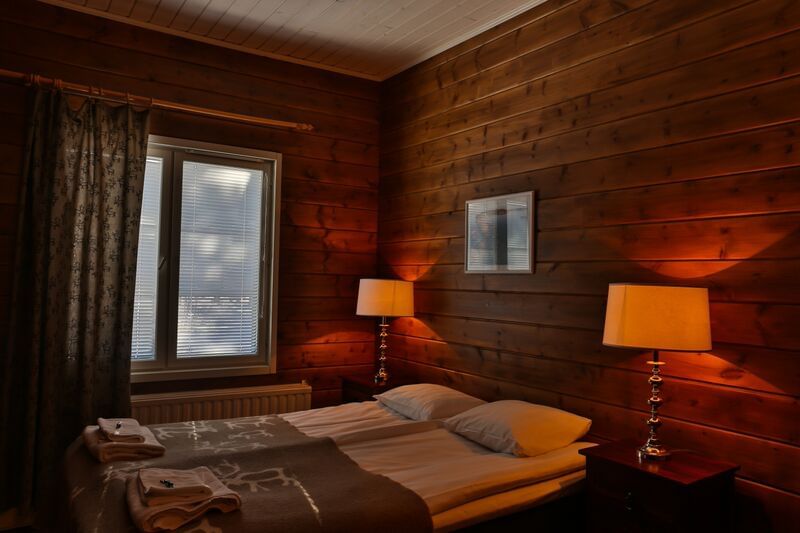 A hotel room with two beds and wooden walls
