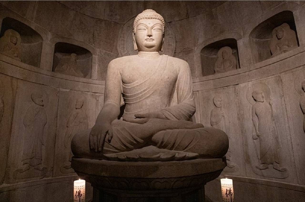 A large seated Buddha statue inside the Seokguram Grotto chamber.