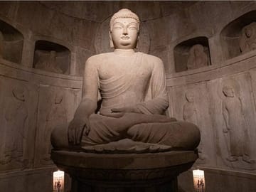 The serene stone Buddha statue inside Seokguram Grotto.