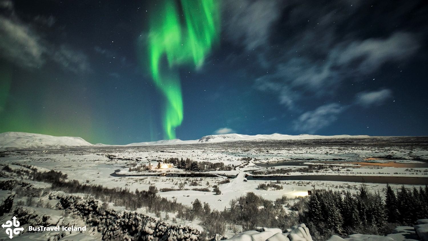 Green Northern lights strip over snowy Thingvellir national park in Iceland