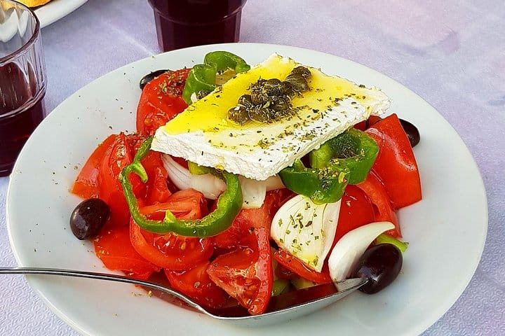 Greek salad with feta cheese and olives and red wine from the barrell