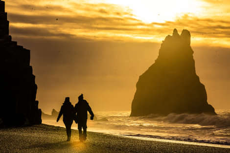 Black Sand Beach with people holding hands and walking