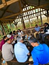 A group of travelers seated together tasting fresh local fruits during a Chagga cultural tour.