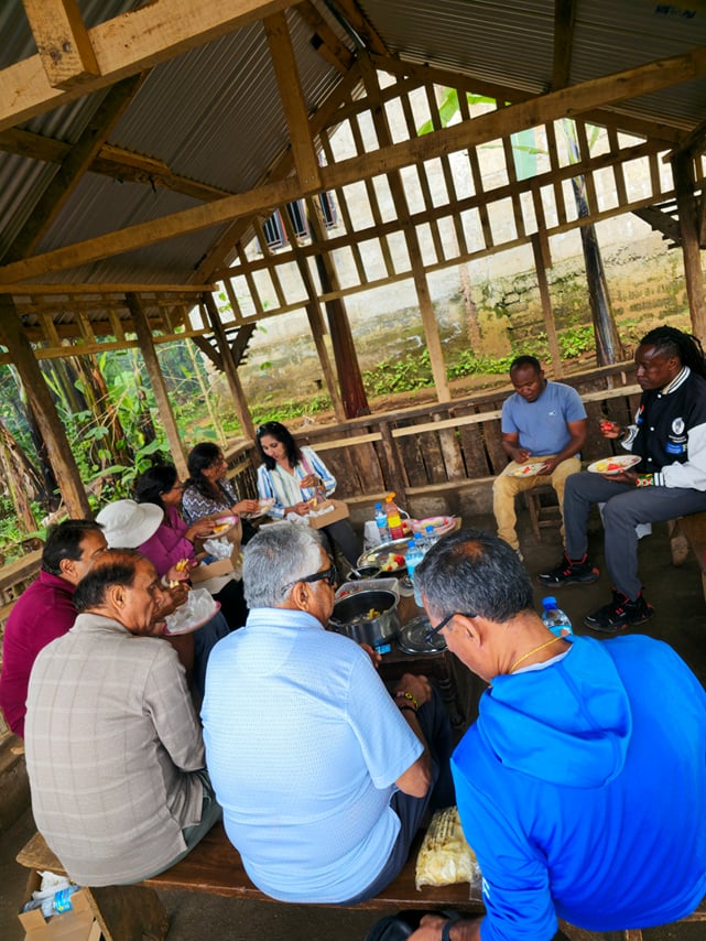 A group of travelers seated together tasting fresh local fruits during a Chagga cultural tour.