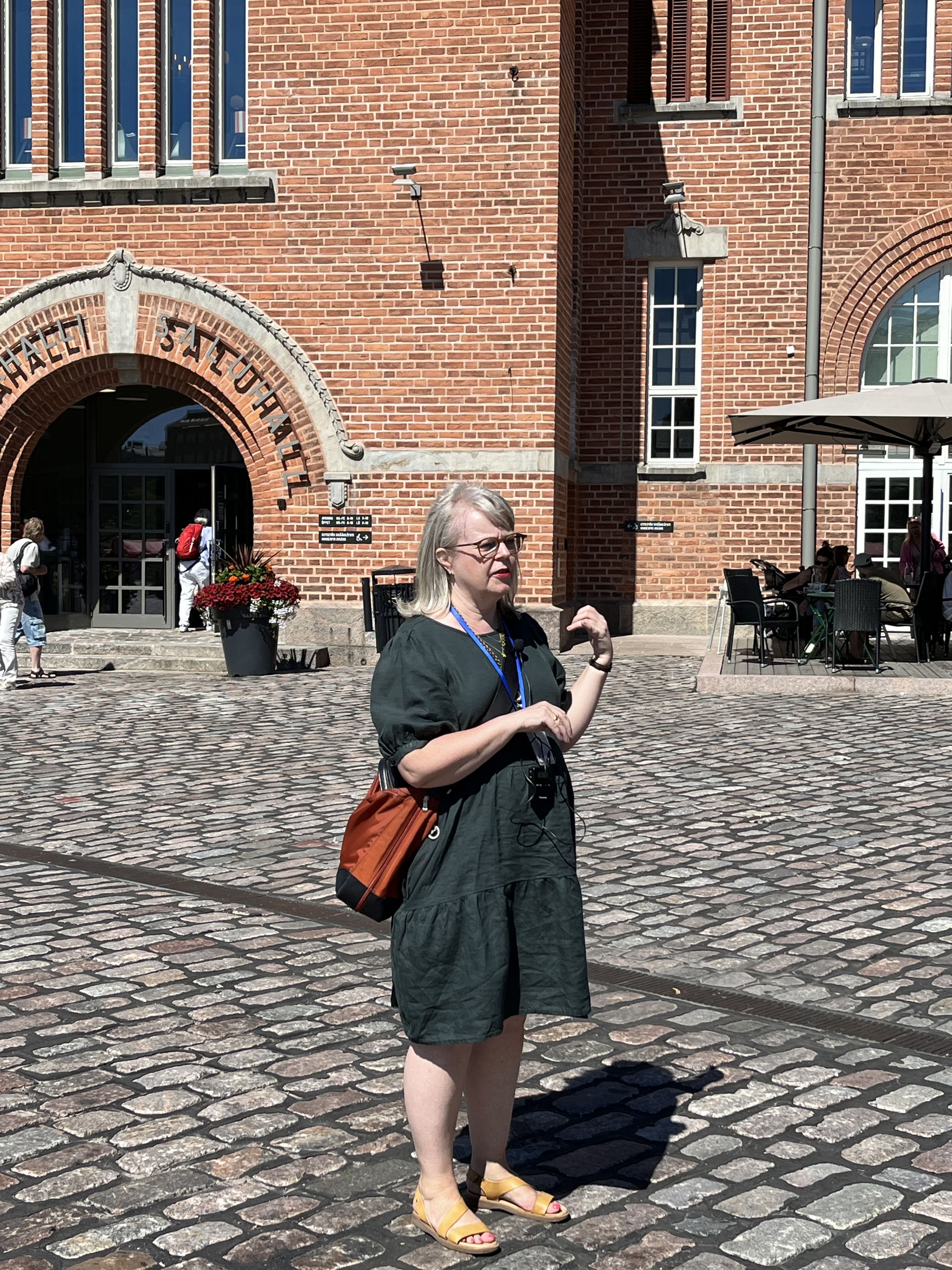 Opas seisoo kauppahallin edustalla torilla