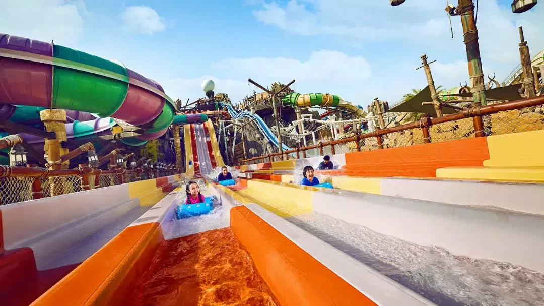 People ride down parallel colorful water slides at Yas Waterworld, Abu Dhabi.
