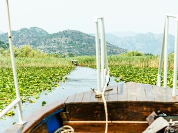 Lake Skadar’s serene beauty unfolds as you cruise towards the picturesque village of Karuč.