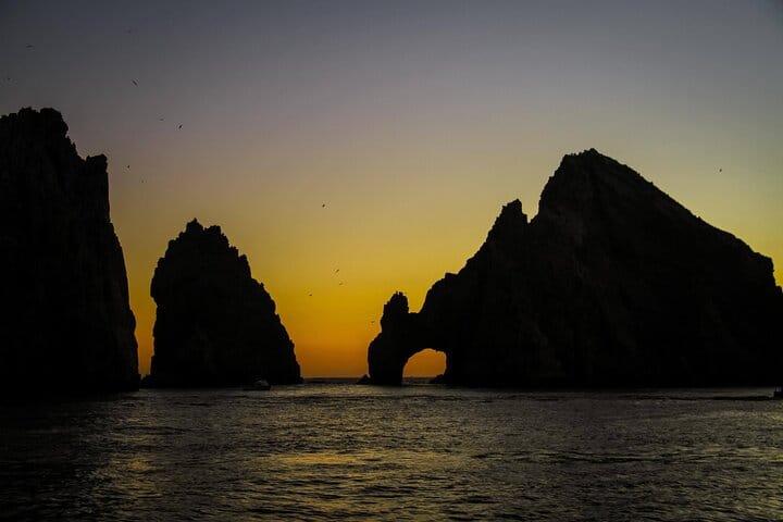 Sail past the iconic rock formations of Los Cabos as the sky glows at sunset—your private catamaran experience includes stunning views, relaxed vibes, snacks, and an open bar.