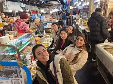Experience authentic Korean street food at Gwangjang Market —A vendor at Gwangjang Market selling traditional Korean street food such as pancakes and seafood.