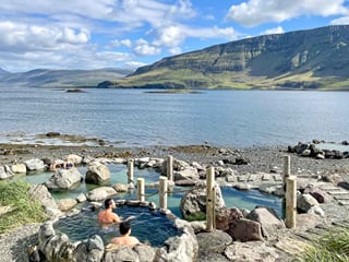 People relaxing in the hot geothermal waters at Hvammsvik