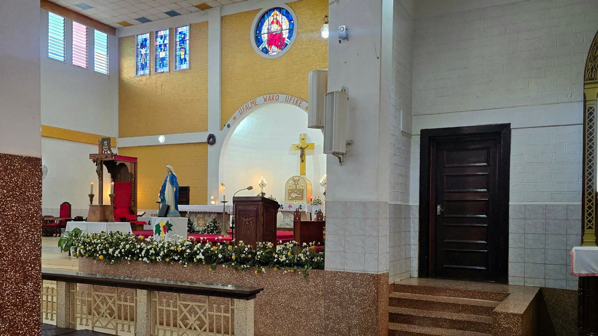 Interior shot showing colorful stained-glass windows and decorative elements near the cathedral altar.