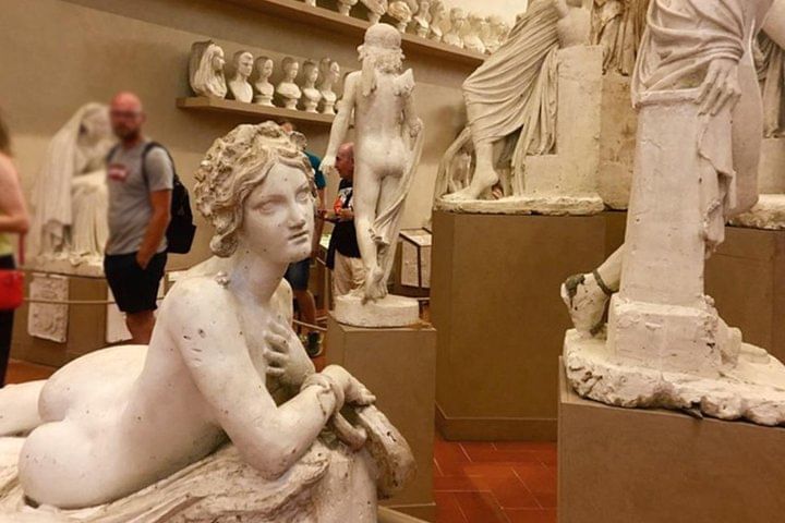 View of one of the halls of the Accademia Gallery with marble sculptures on display