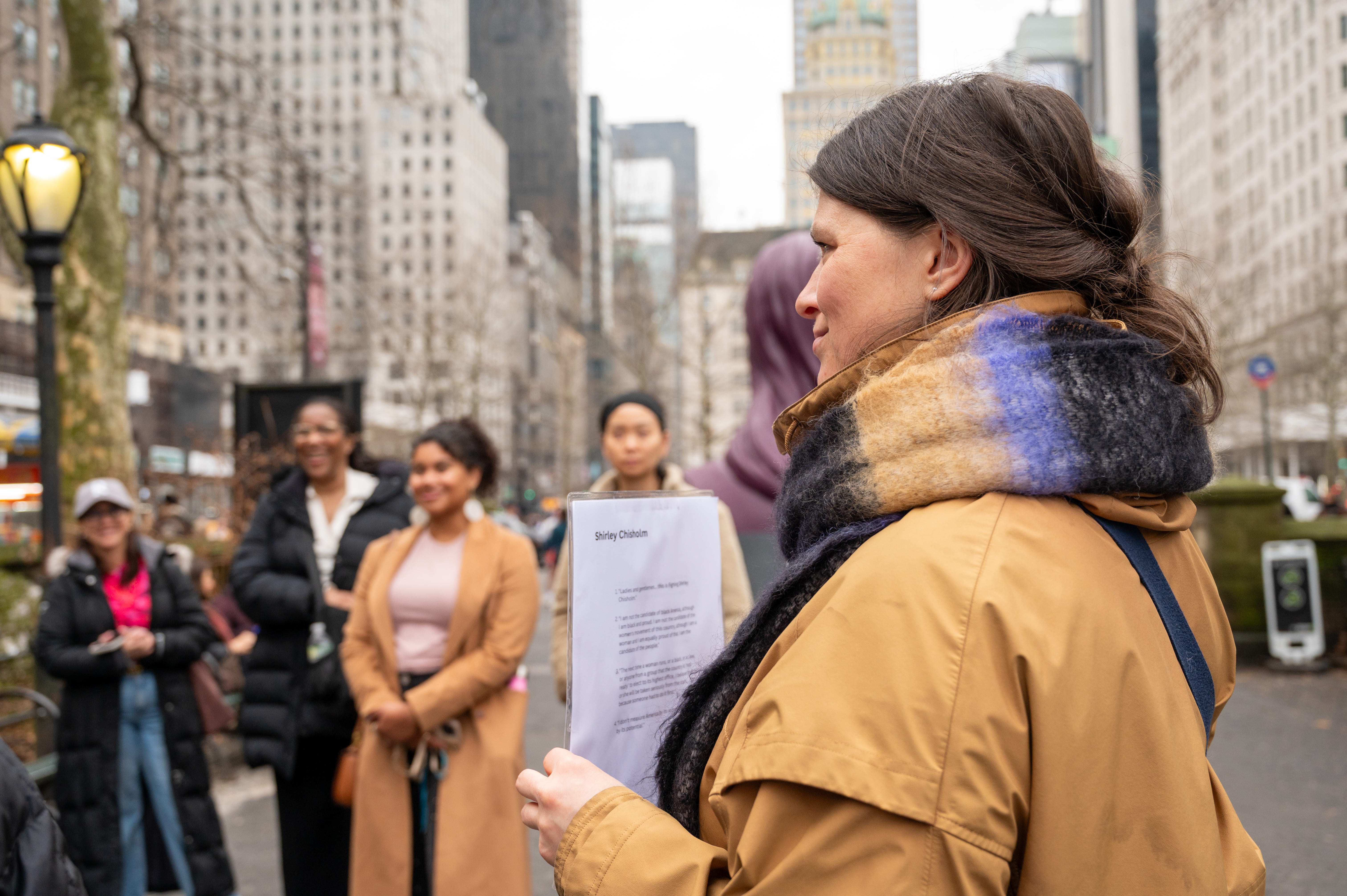 The group gathers around to hear a story of a women NYC's history forgets (but we don't!)