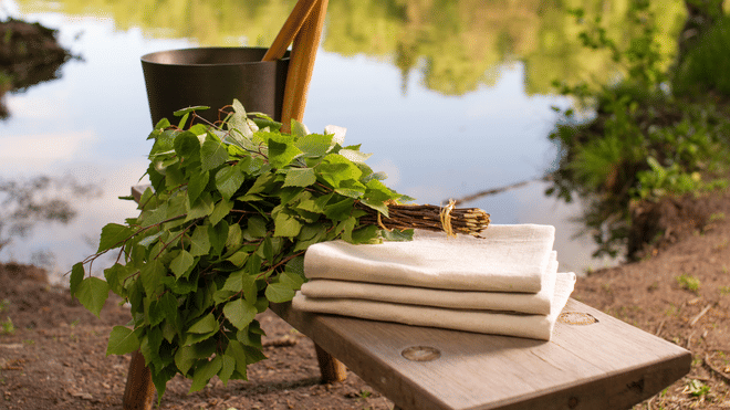 Birch leaves and sauna essentials including towels and a bucket, ready for a Traditional Finnish Sauna Experience in Rovaniemi, StayLapland.