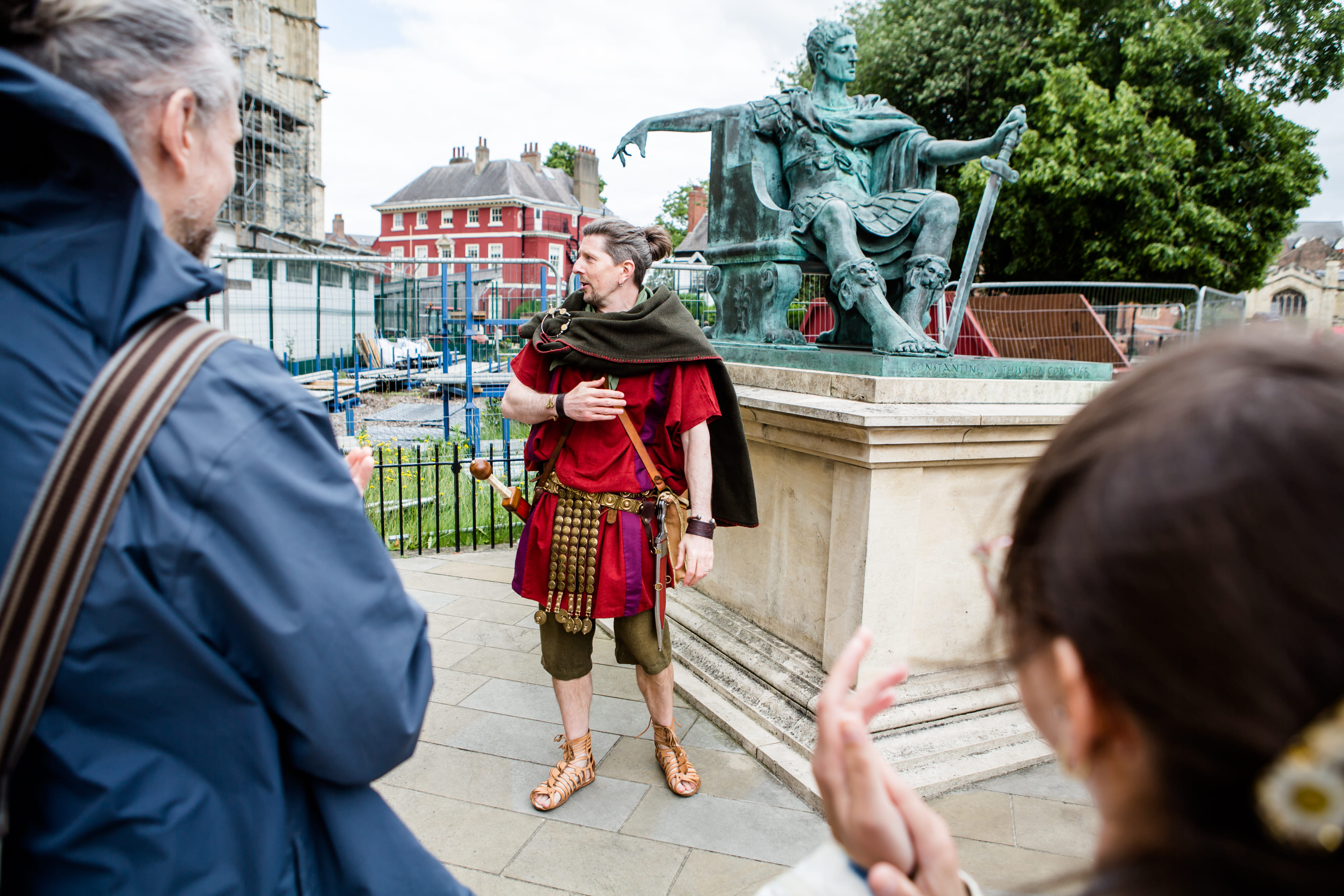 A Roman legionary stands besides the statue of Constantine the Great, besides York Minster, with his crowd gathered around.