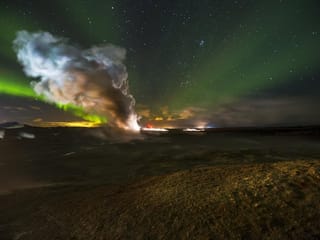 Northern Lights behind a column of steam coming from one of Iceland's largest geothermal areas.