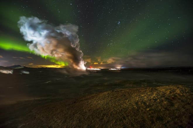 Northern Lights behind a column of steam coming from one of Iceland's largest geothermal areas.