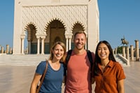 Tourists enjoying a friendly moment in front of the Mohammed V Mausoleum and the Hassan Tower.