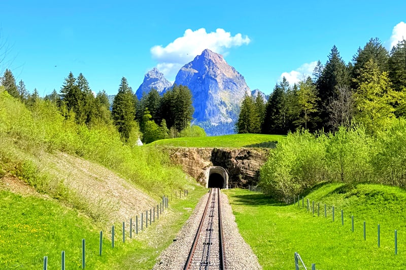 Os trilhos do funicular do Stoos, com os picos dos Mythen ao fundo.