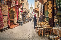 Lively streets of the souks of the medina of Fez, lined with Moroccan craft shops, traditional carpets and copper objects, in the heart of a UNESCO World Heritage district.