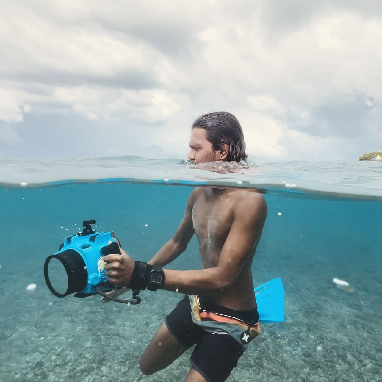 Fotógrafo de surf capturando fotos de acción en la isla Himmafushi, organizadas por ForBeyond Travel