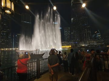 Layover guest enjoying Fountain show at Dubai mall with Burj Khalifa at the background during their stopover in dubai.