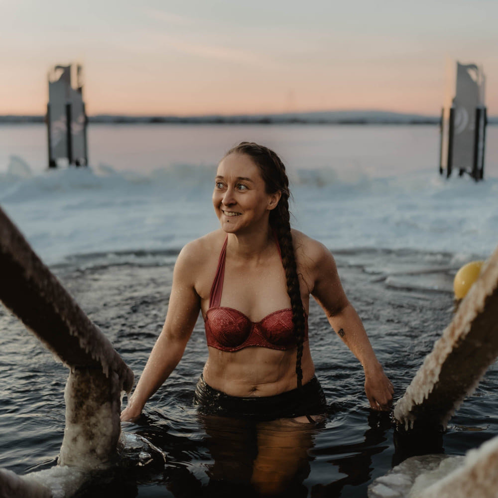 A woman is happy after ice swimming at Roiske Arctic Sauna Retreat